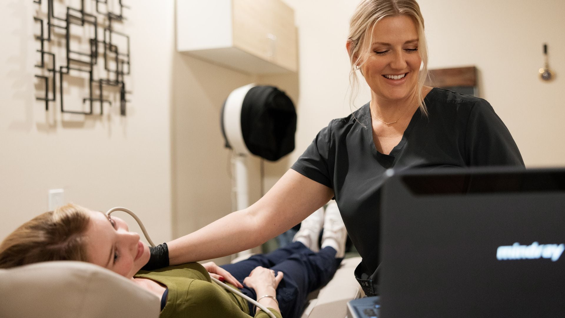 Natalie smiling while scanning a patient's neck