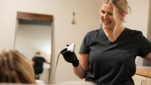 Natalie laughing with a patient as she prepares the ultrasound probe