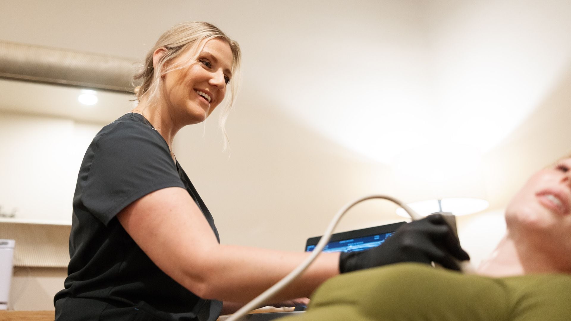 Natalie smiling mid-scan with a patient