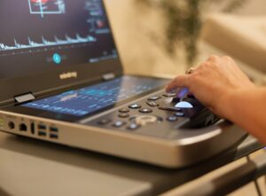Natalie adjusting settings on the ultrasound scanner control panel